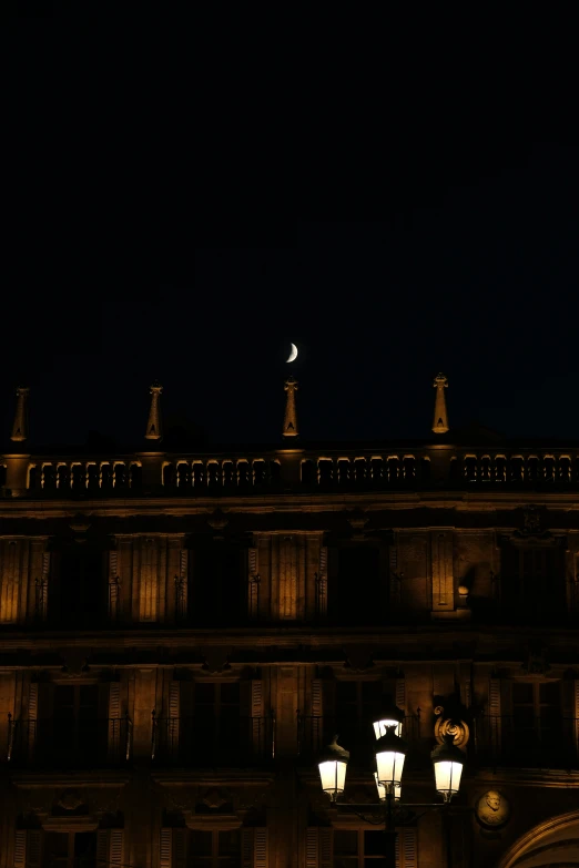 an ornate building at night with street lamps lit in front of it