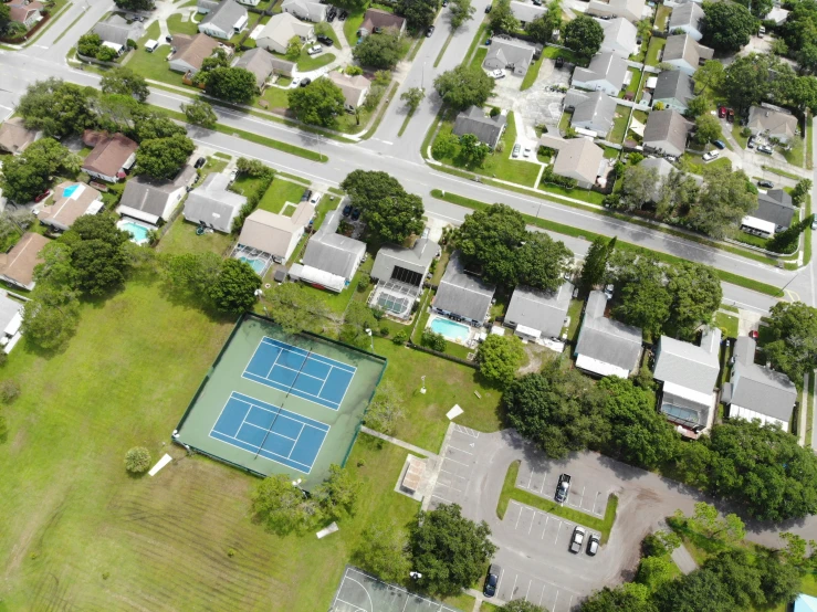 an aerial view of a suburban area with a tennis court
