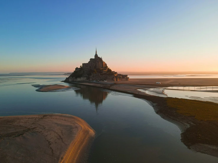 an island in the water is seen at sunset