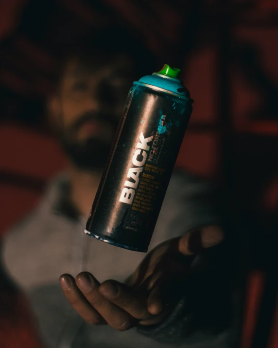 a person holding up an energy drink in their hand