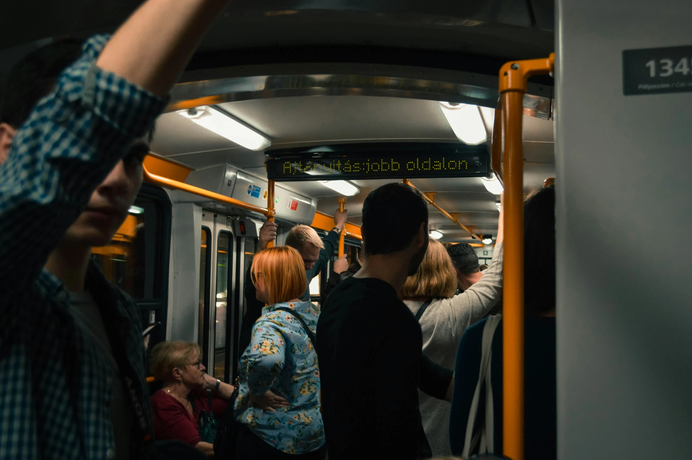 people are standing inside a subway car while others sit