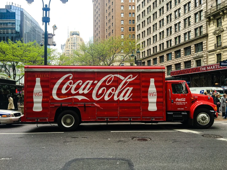 a truck on a street with coca - cola painted on it