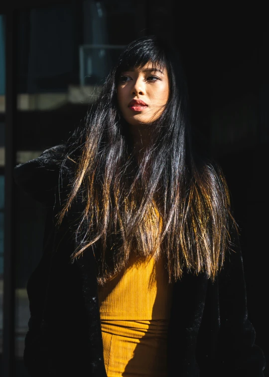 a young woman with long hair wearing a yellow dress