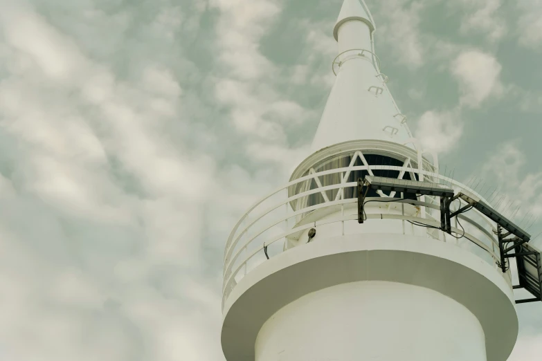 an old fashioned po of a tall white tower with a sky background