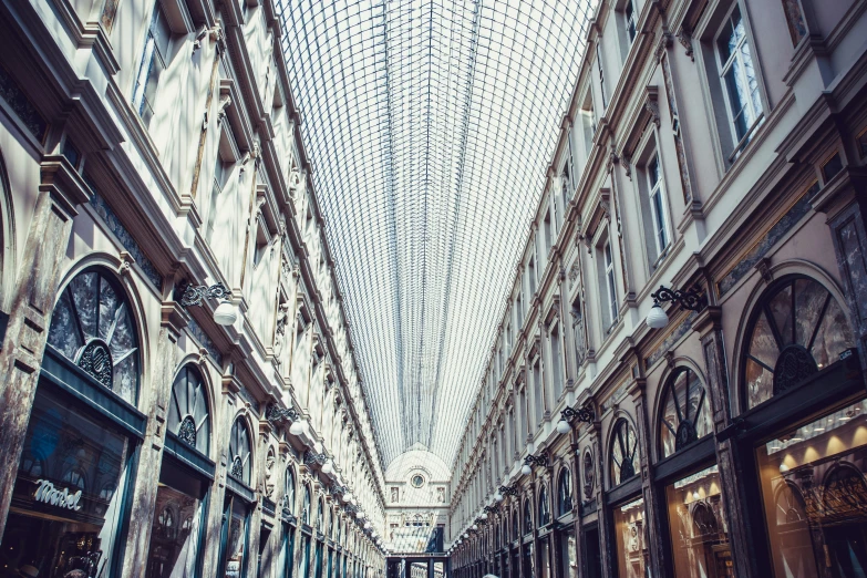 a narrow street with shoppers and shops lining the side