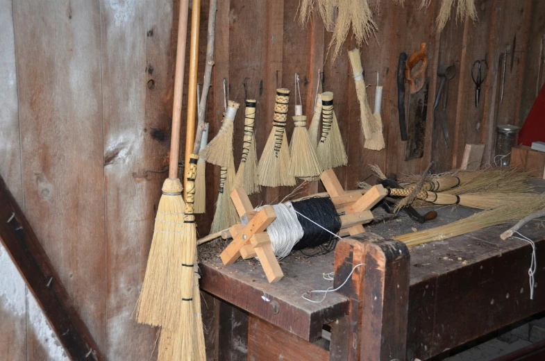 brooms and other tools sitting on a table in a shed