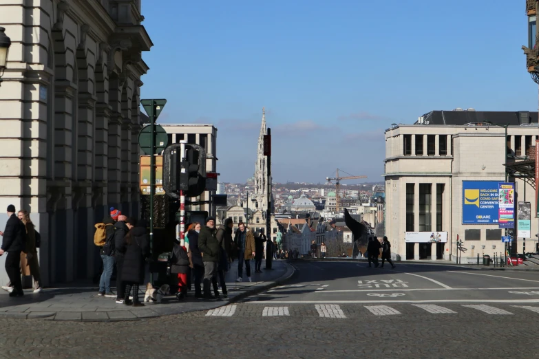 a crowd of people crossing a street in a city