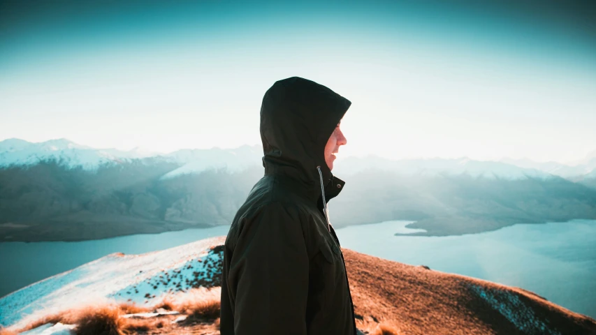 a person looking over a mountain lake at a foggy day