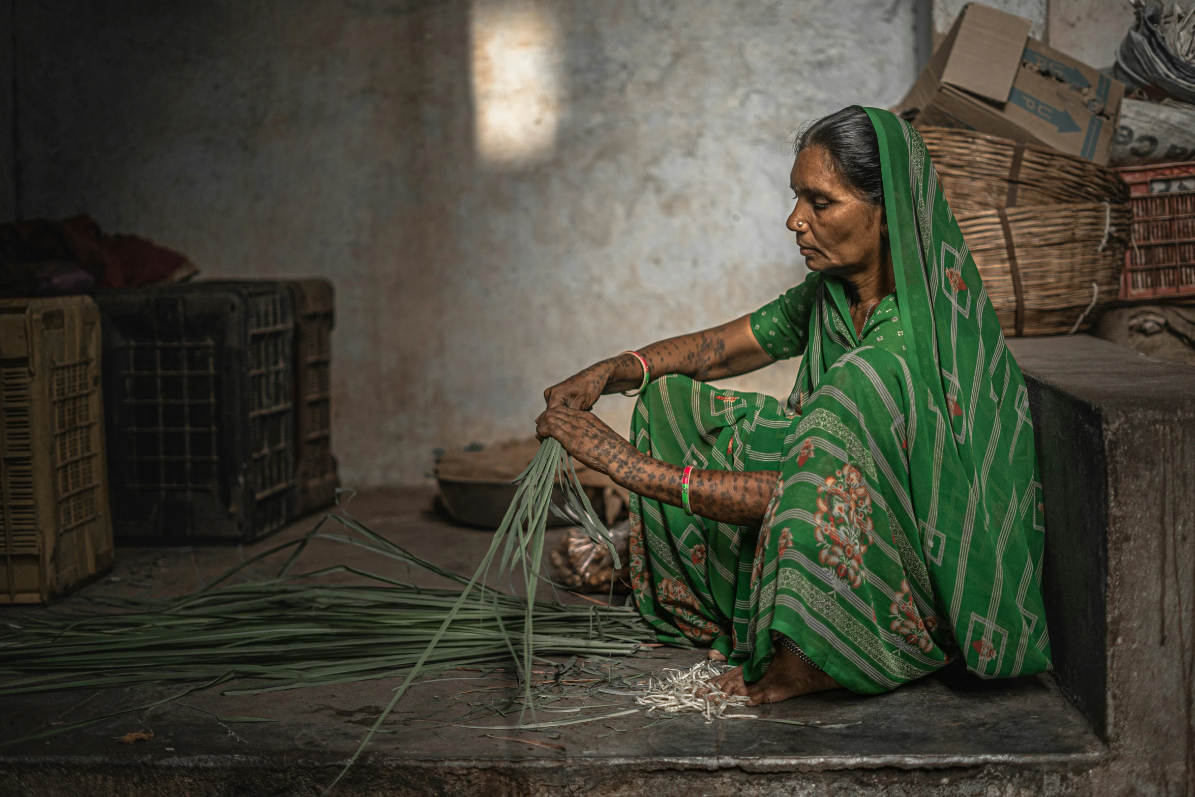 an indian woman working on weavings and bamboo