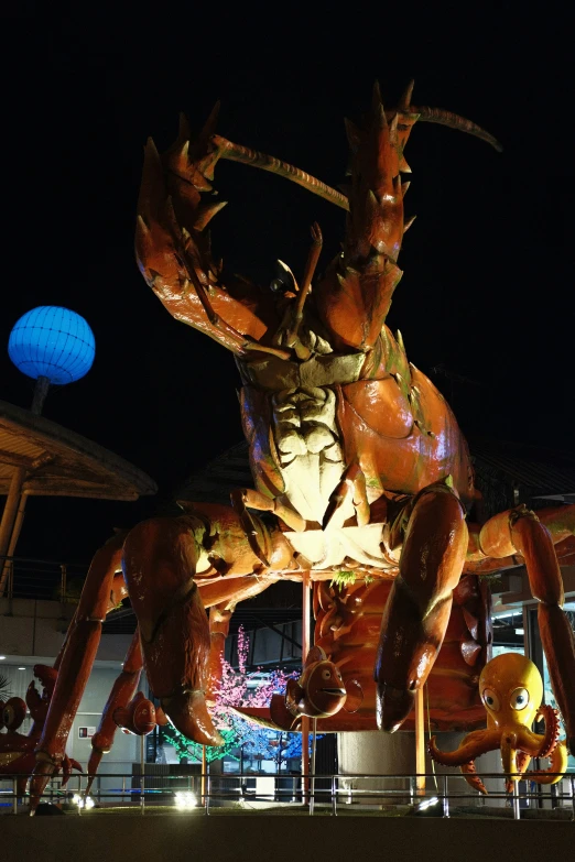 a large statue of a large spider next to a blue ball