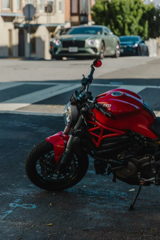 red motorcycle parked next to a curb in a parking lot