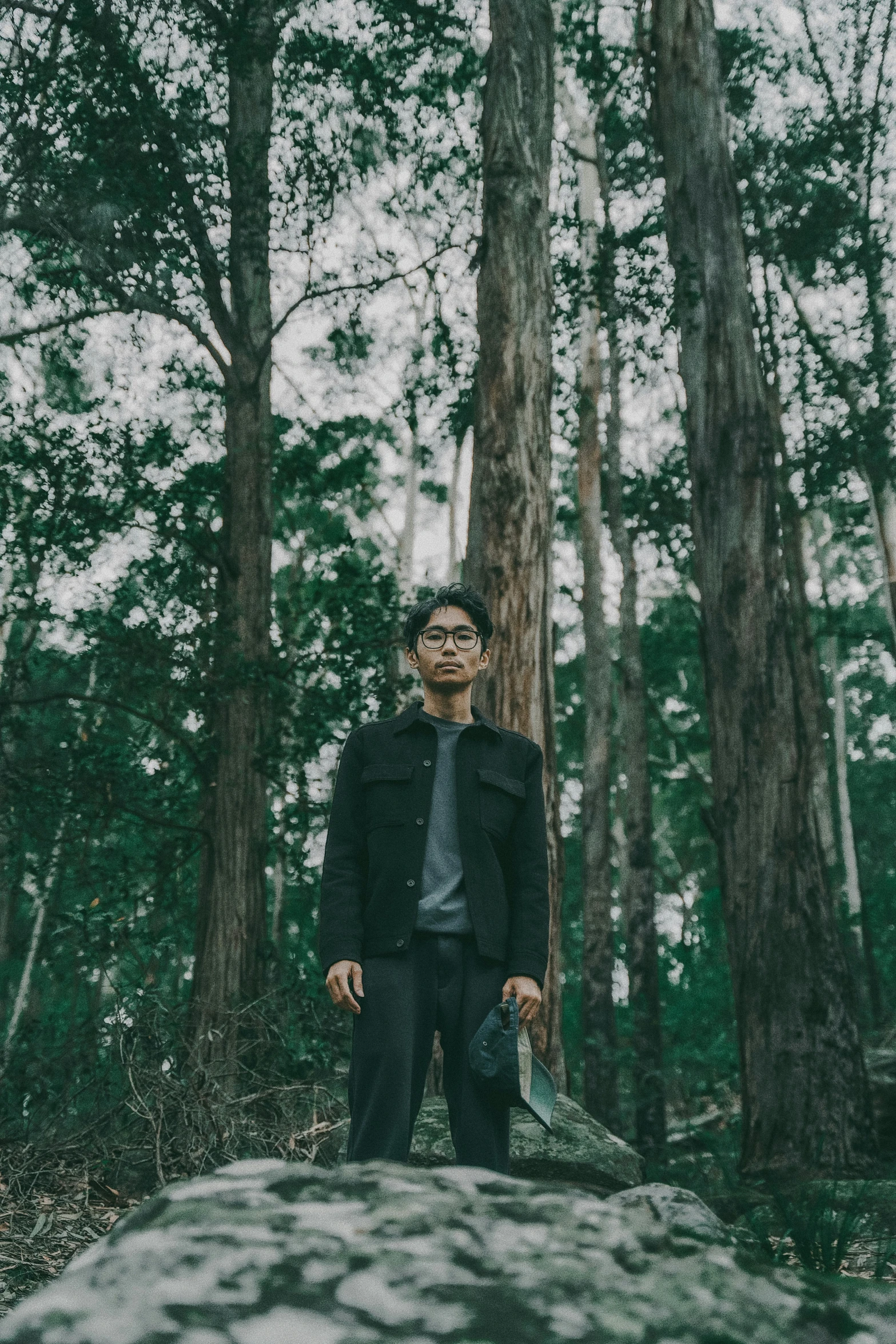 a man is standing alone in the middle of the woods