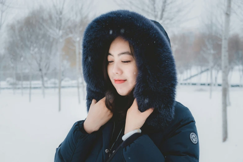 a woman in black jacket with sherpad covering her face