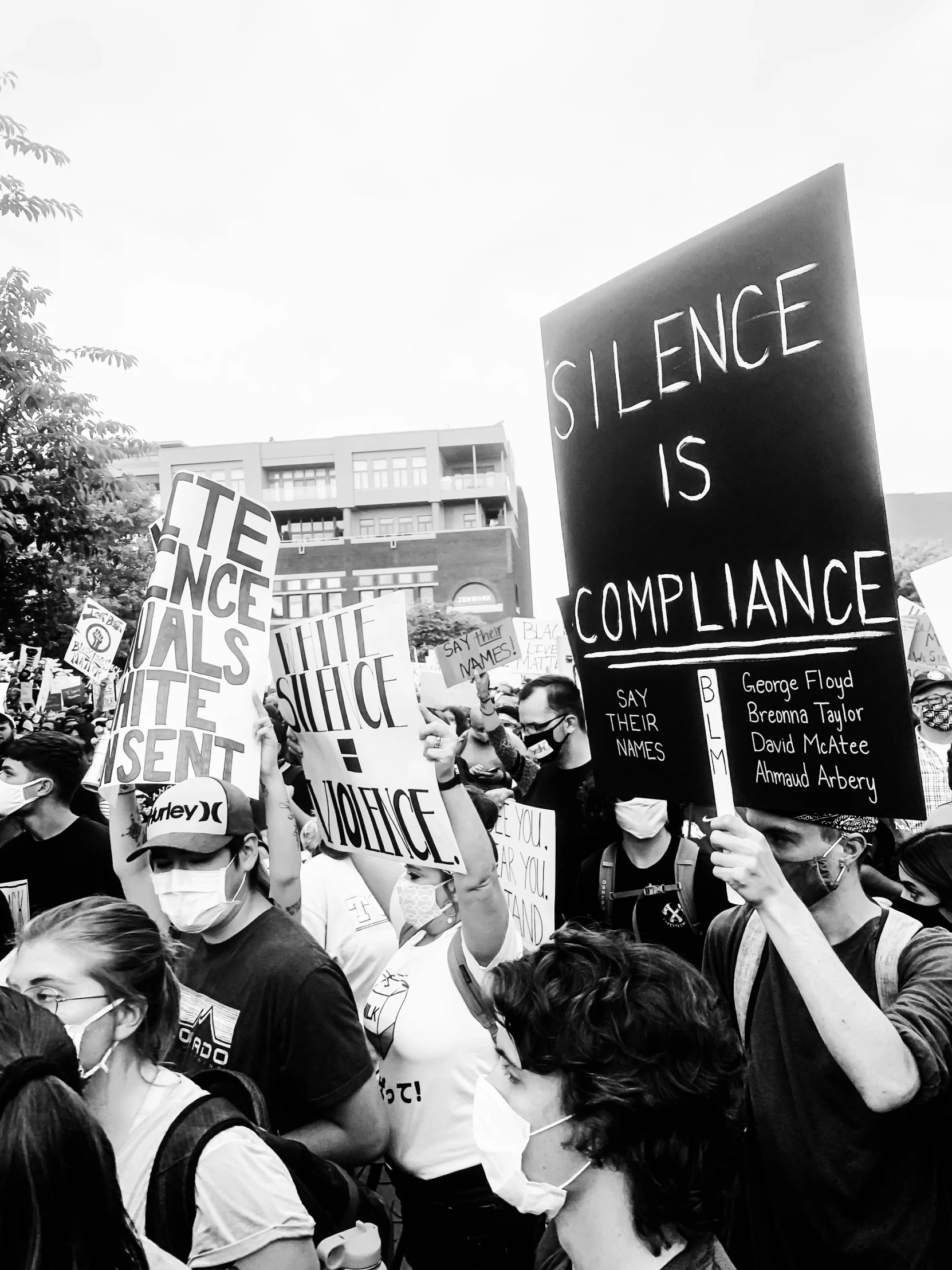 a group of people protesting with signs and face masks