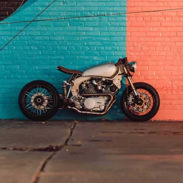 a motorcycle parked next to a blue and pink wall