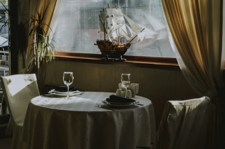 an image of dining table set with an ocean boat window view