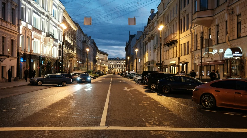 a street scene with cars on the side and buildings in the background