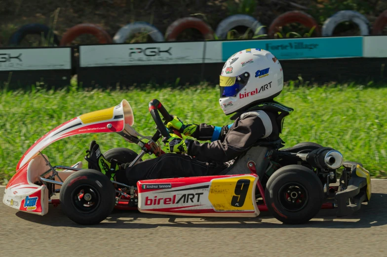 a person with a helmet riding in a go kart