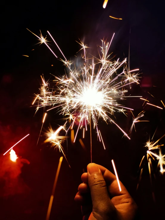 someone is holding a brightly lit fireworks on a night