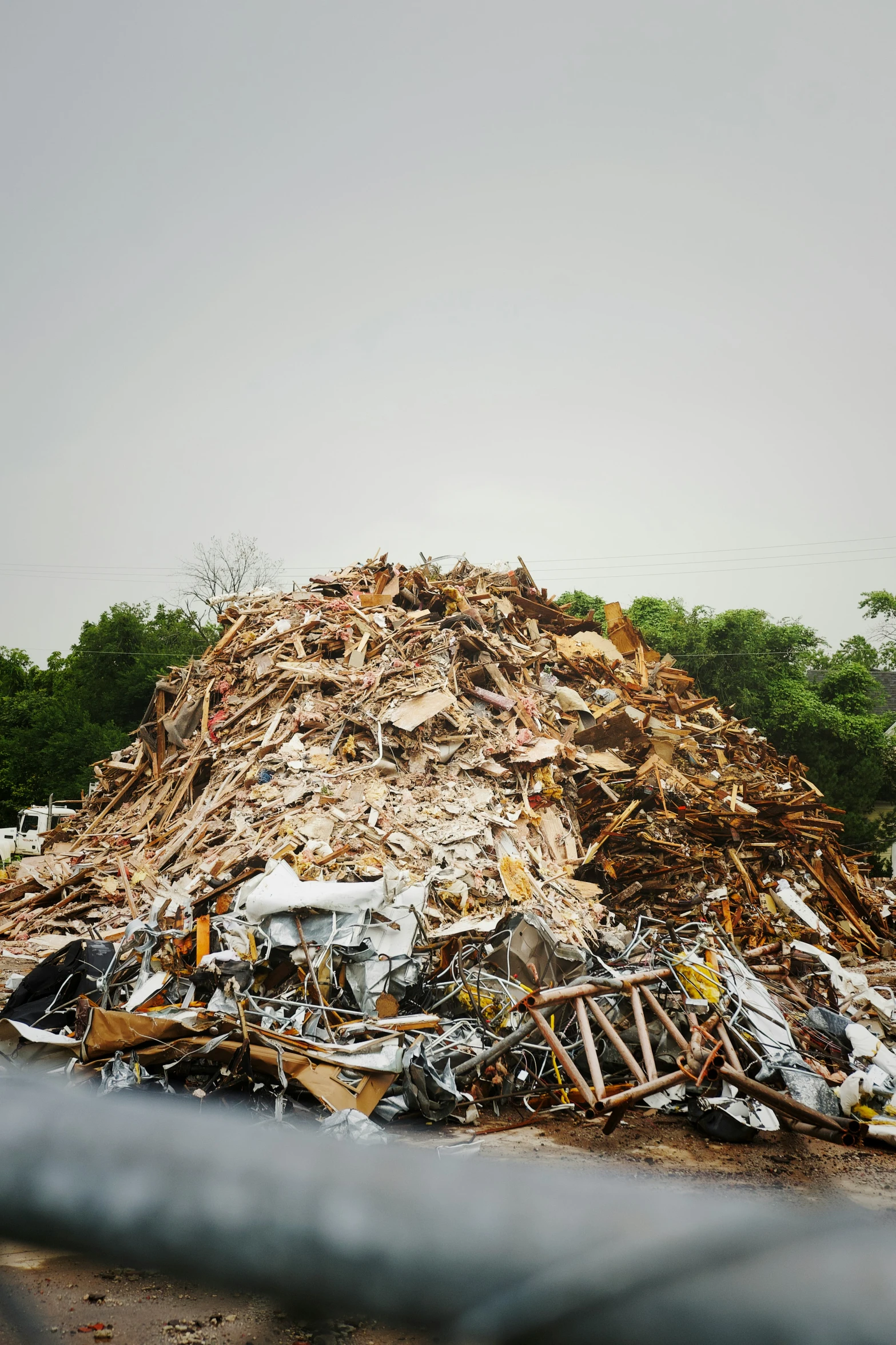 a big pile of garbage sitting on top of a large metal fence