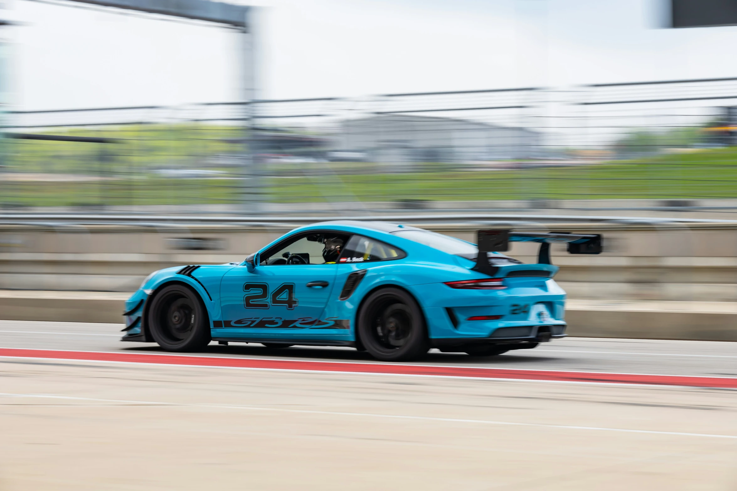 a blue racing car going around a corner