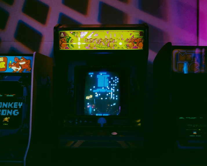four video game machines in an alley at night