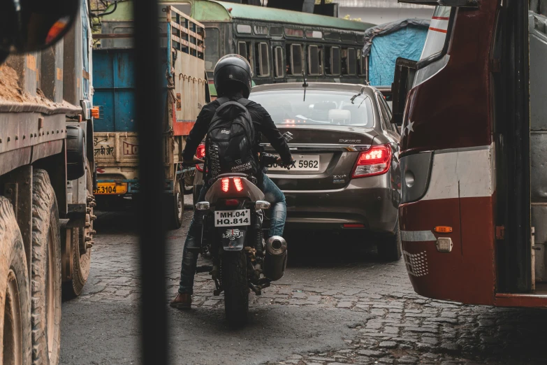 a person on a motorcycle riding through traffic