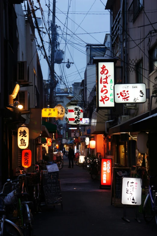 some signs and lights for the shops by some buildings