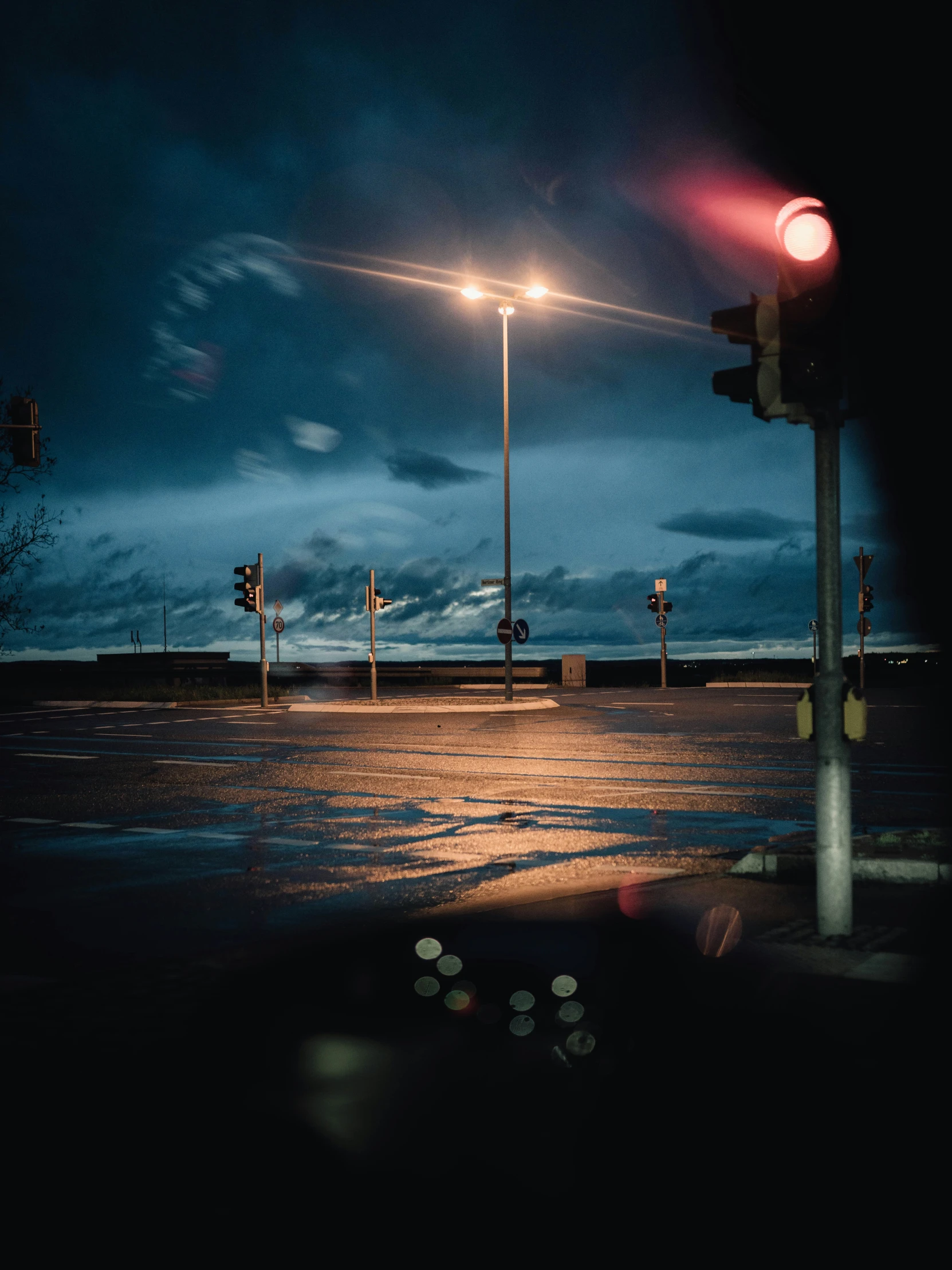 traffic lights shining on a dark rainy night