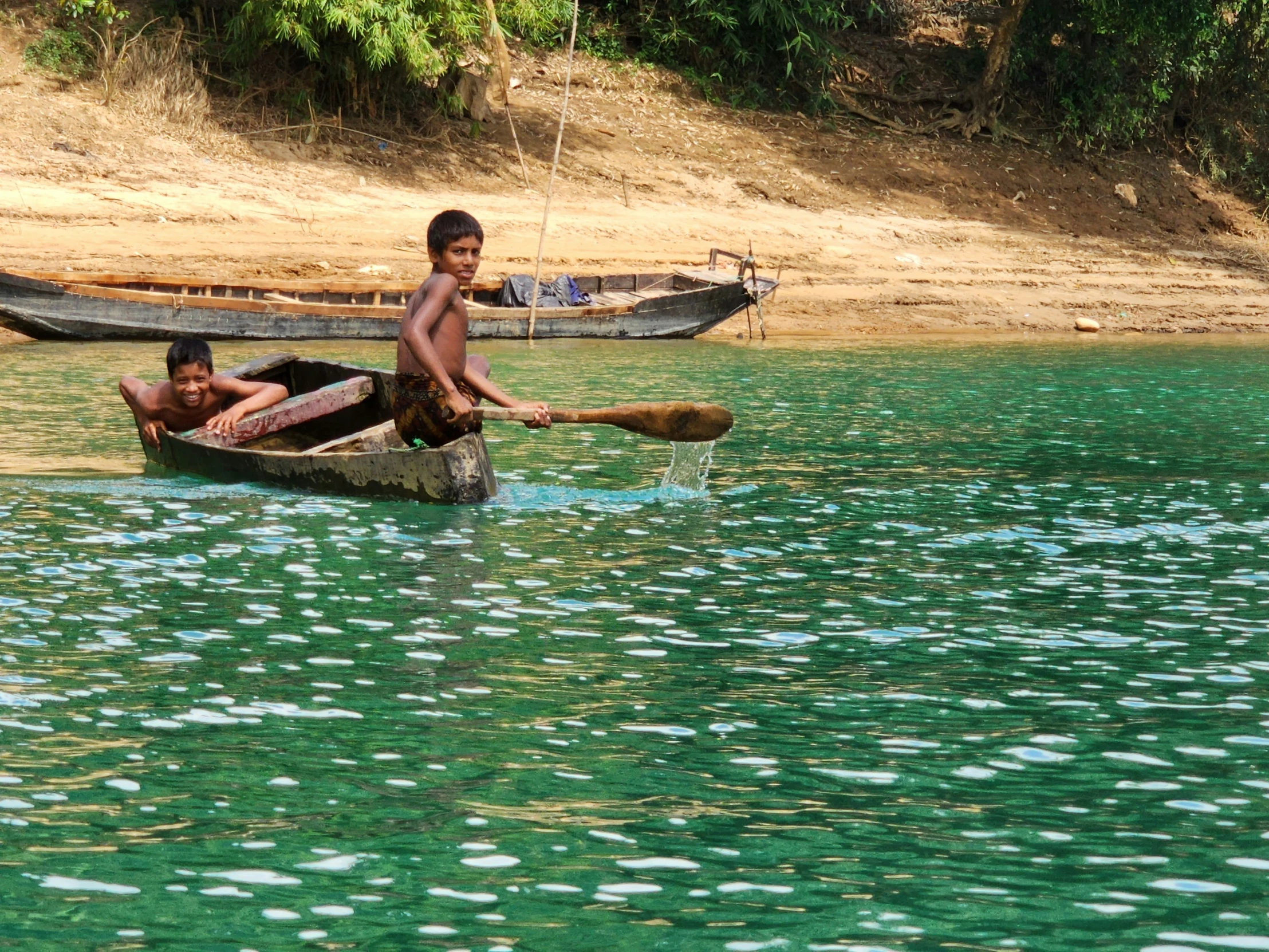 two children on a wooden boat in the water