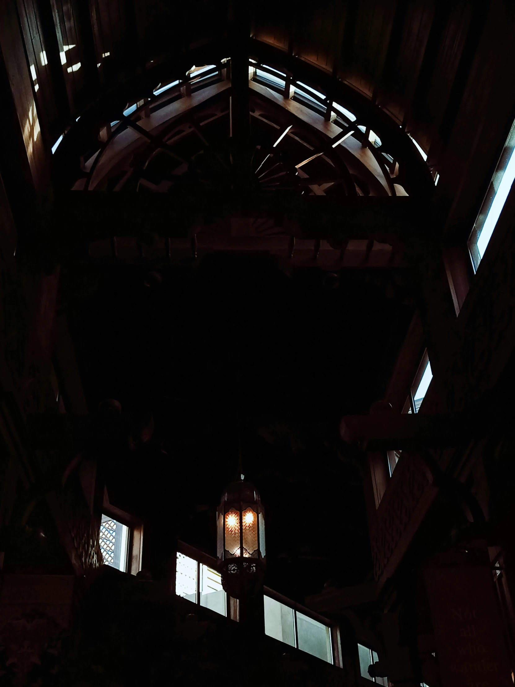 looking up at an illuminated wooden structure at night