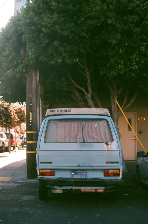 a white van parked on a street next to trees