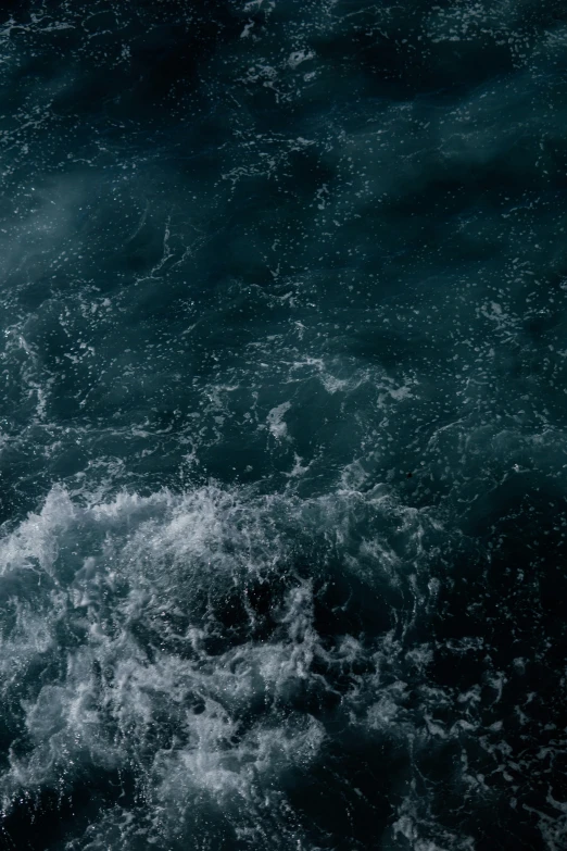 a man swimming in the ocean with a surfboard