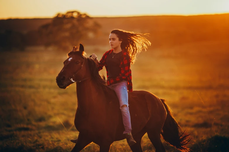 a  riding on the back of a brown horse