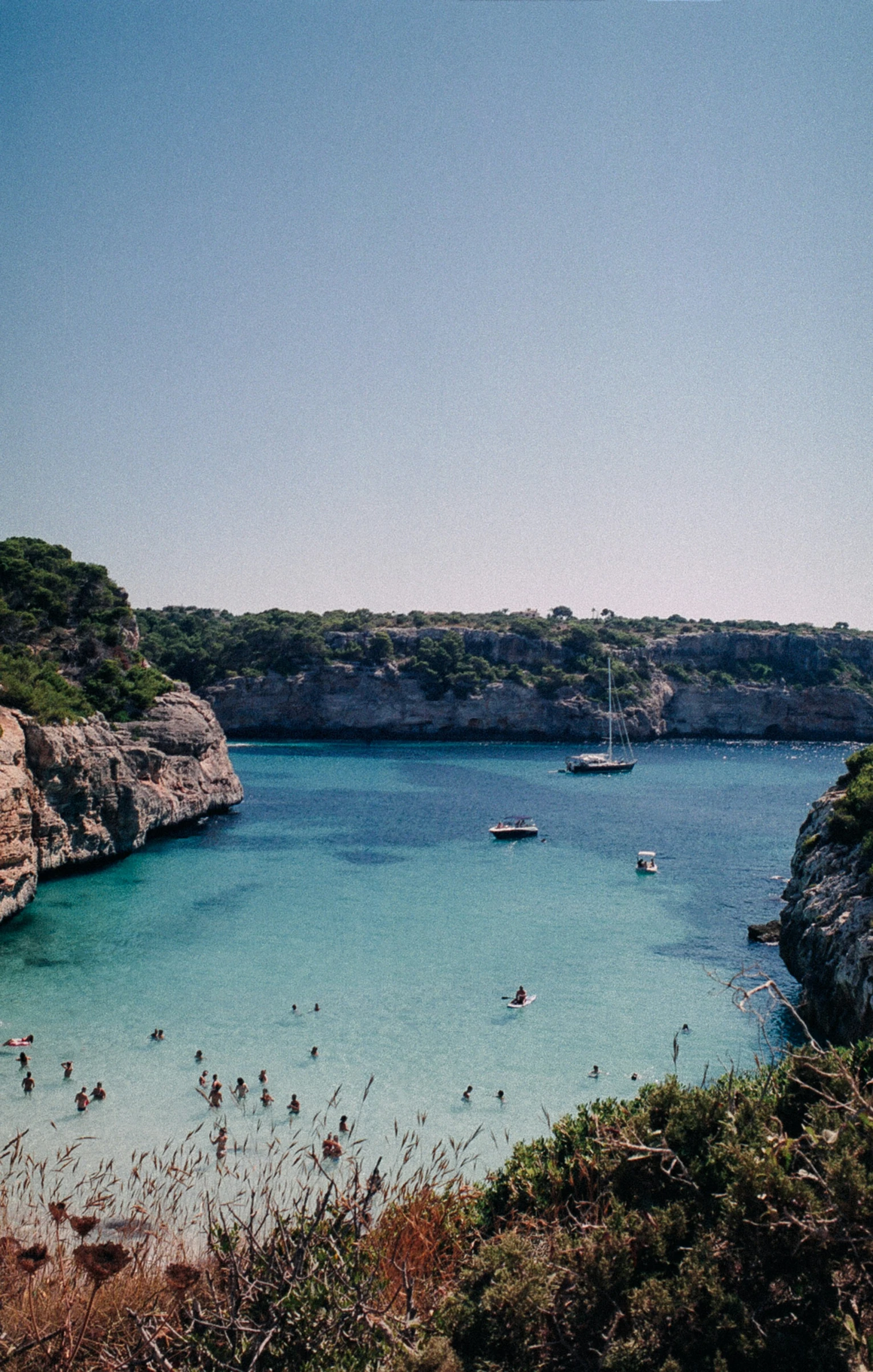 the waters are blue and clear, so boats are floating on them