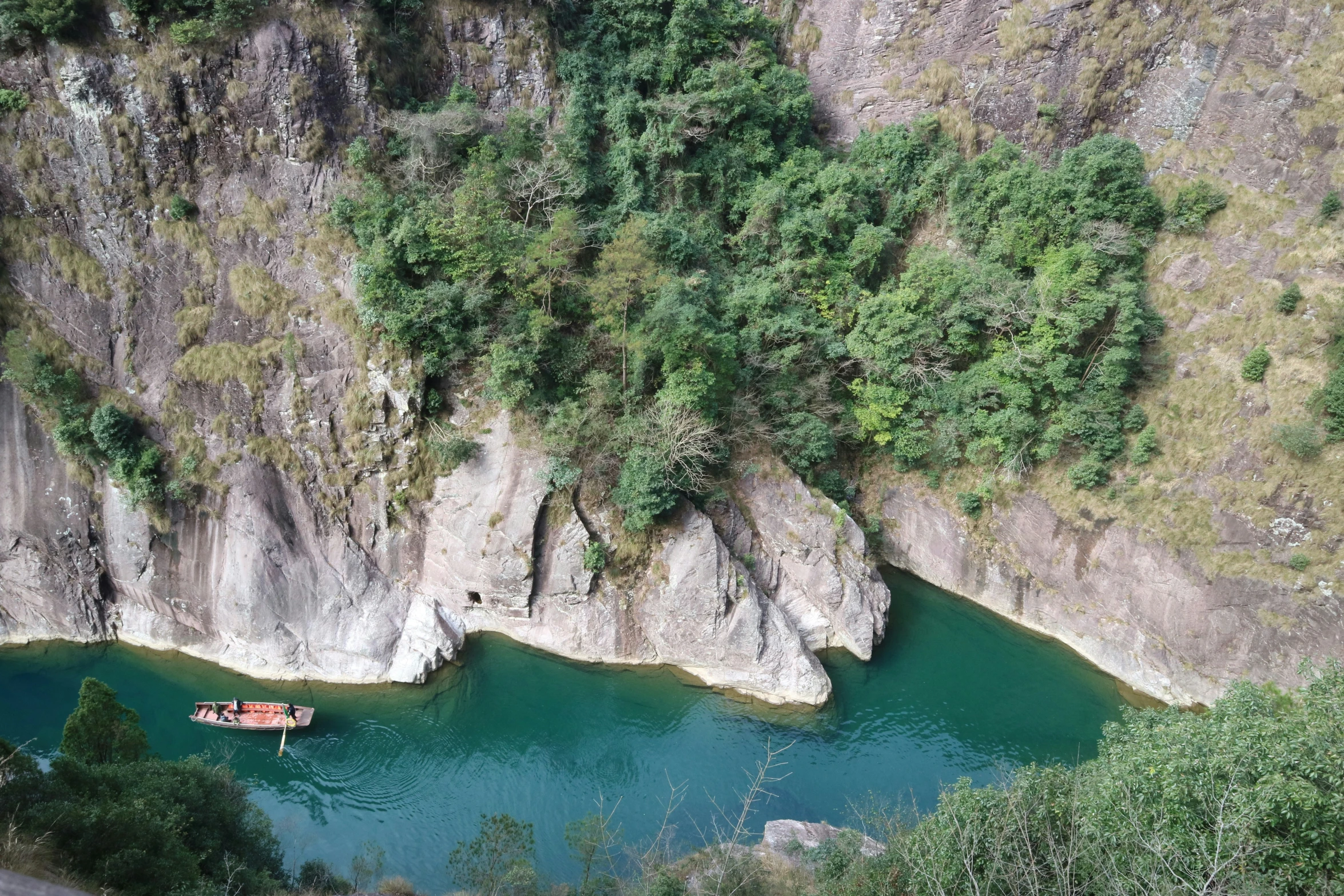 a large lake sitting near a mountain with a boat