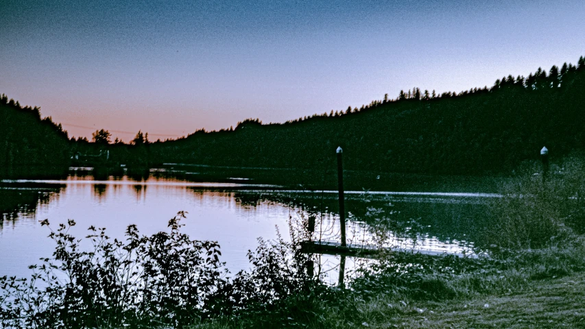 some lights and poles sitting by the water