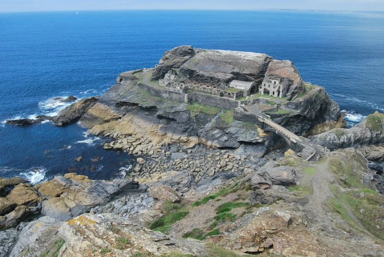 large rocky terrain near the ocean with blue skies