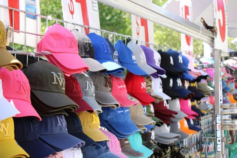 many hats hanging up on a rack