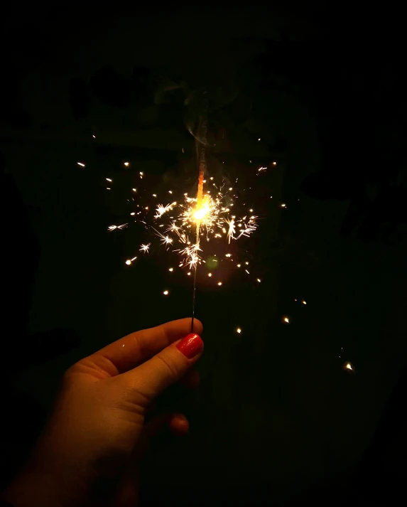 a person holding a sparkler with firework in it