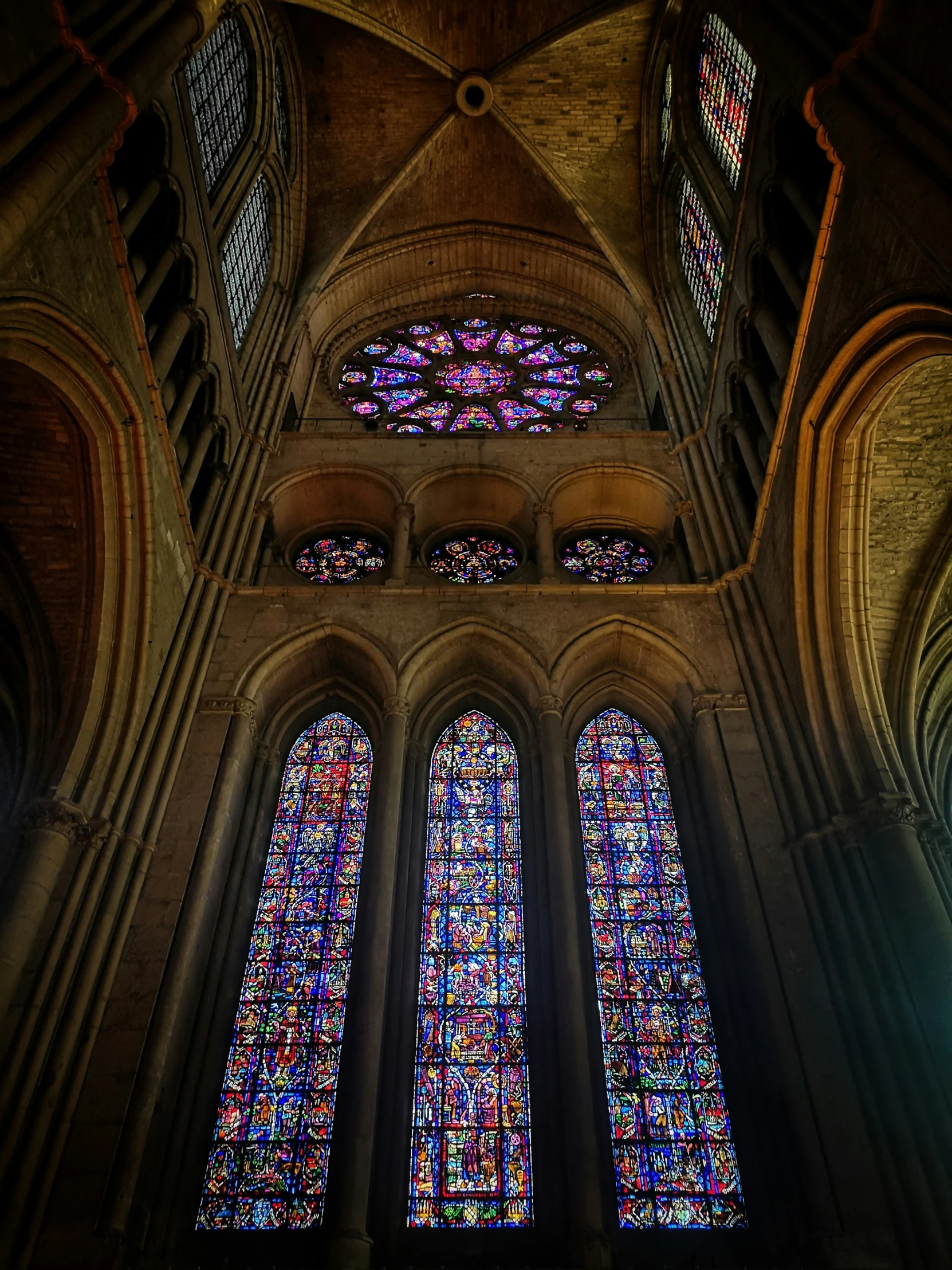 a large cathedral with high vaulted ceilings and a row of stained glass windows