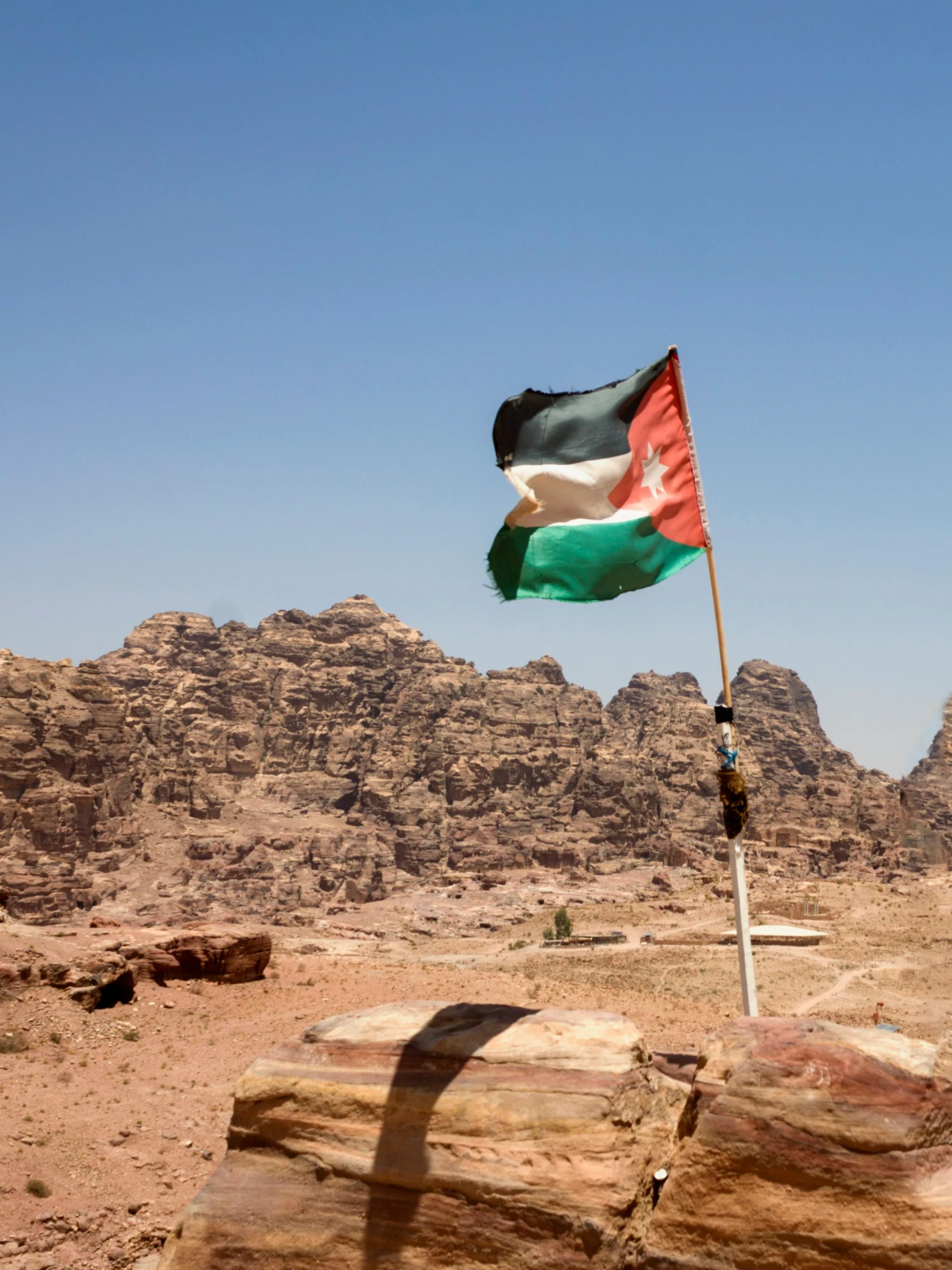 a flag flies in the air above some desert terrain