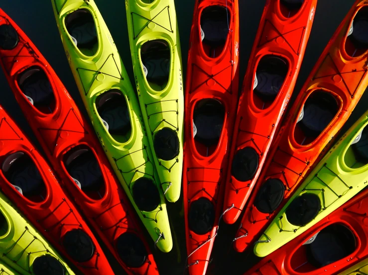 many different colored kayaks all lined up together