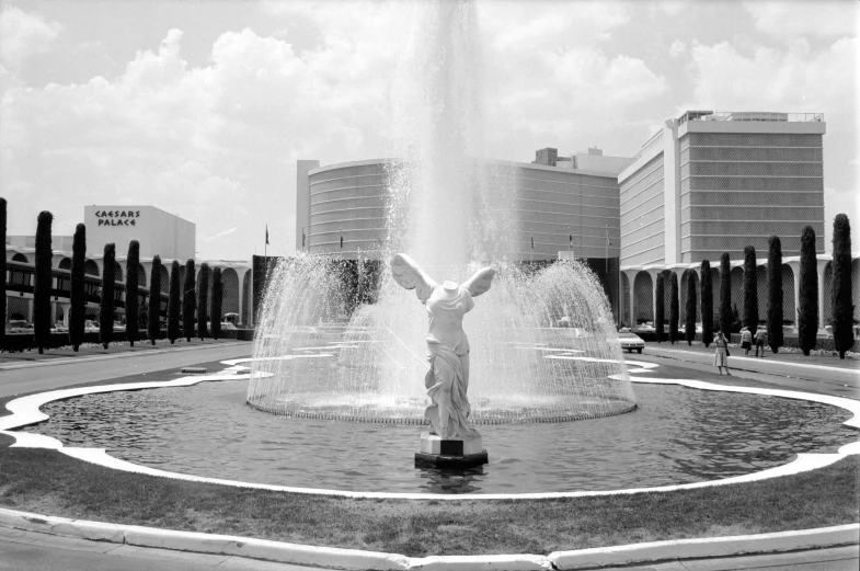 an outdoor fountain has two water jets spraying out of it