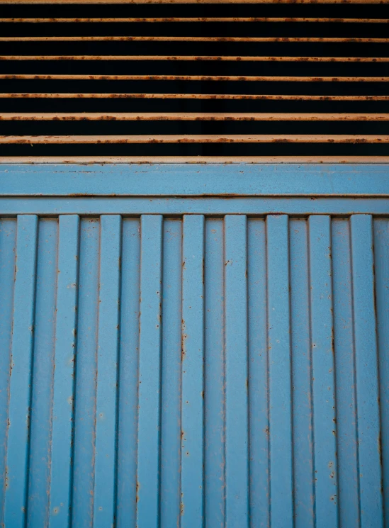 a blue painted wooden bench with a wood slatted seat