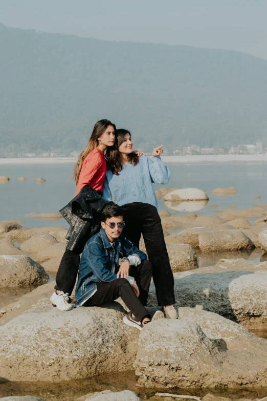 two women sitting on rocks and smiling at the camera