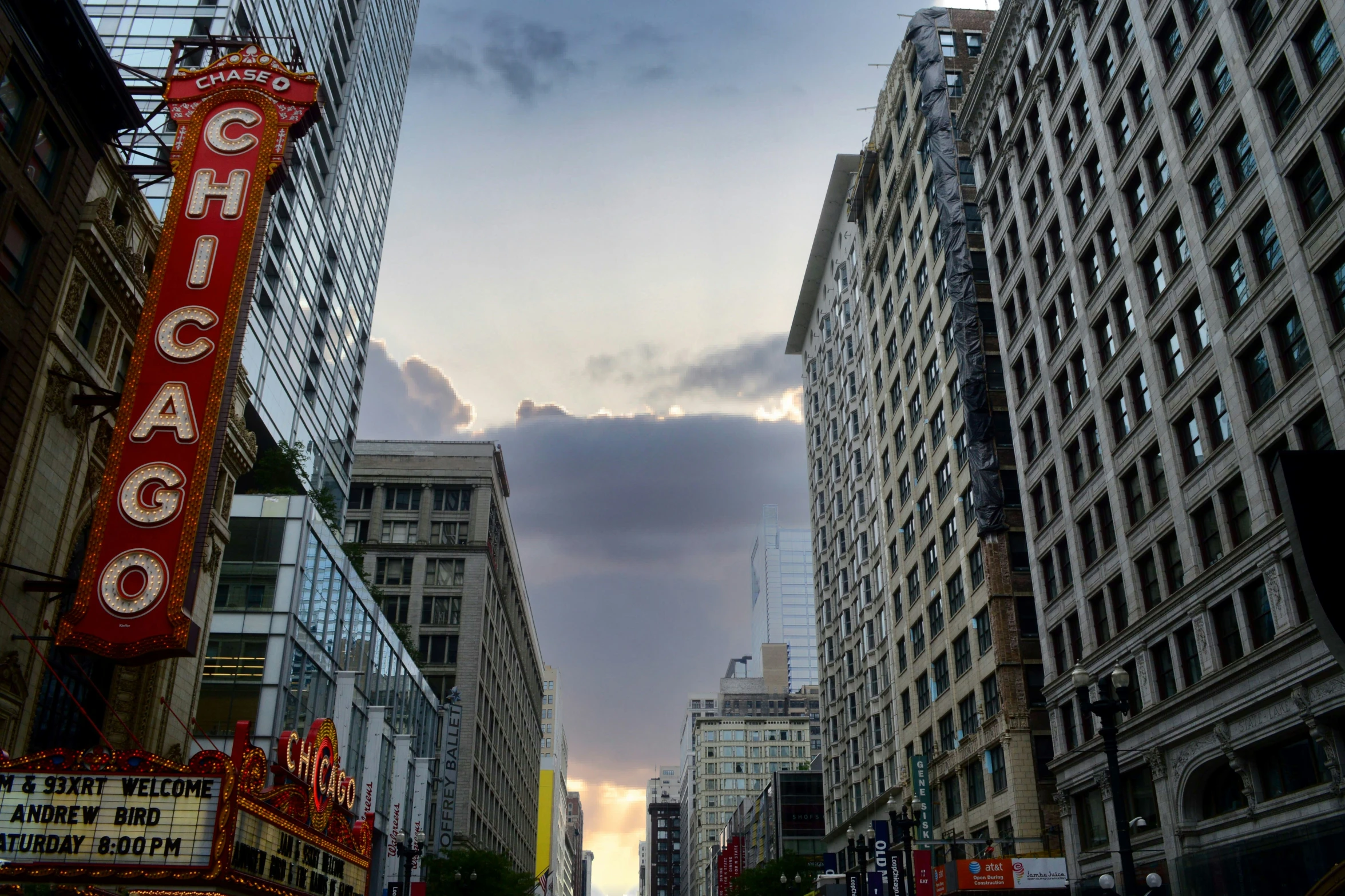 tall buildings are lining a street at dusk