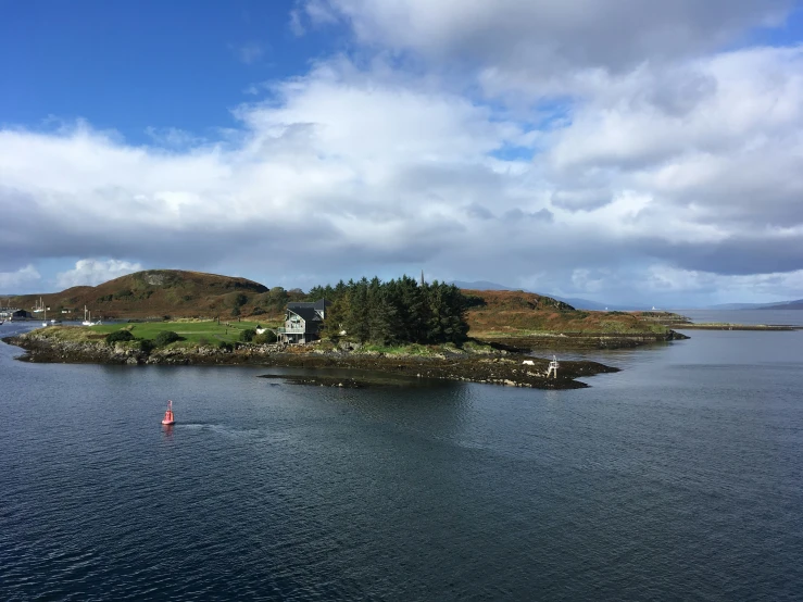 a body of water with houses on a hill near by