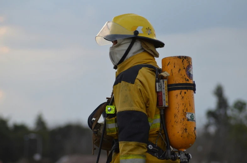fireman holding yellow safety equipment on street