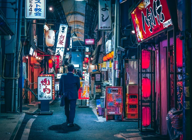 an oriental man standing in a narrow street with colorful lights